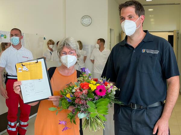 Bild vergrößern: Sabine Dellwisch erhält einen Blumenstrauß vom Leiter des Impfzentrums, Christian Stein